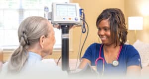 A nurse checking an elderly woman's blood pressure at Fountain Inn